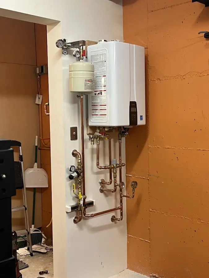 Plumbing technician inspecting water heater connections in Minden